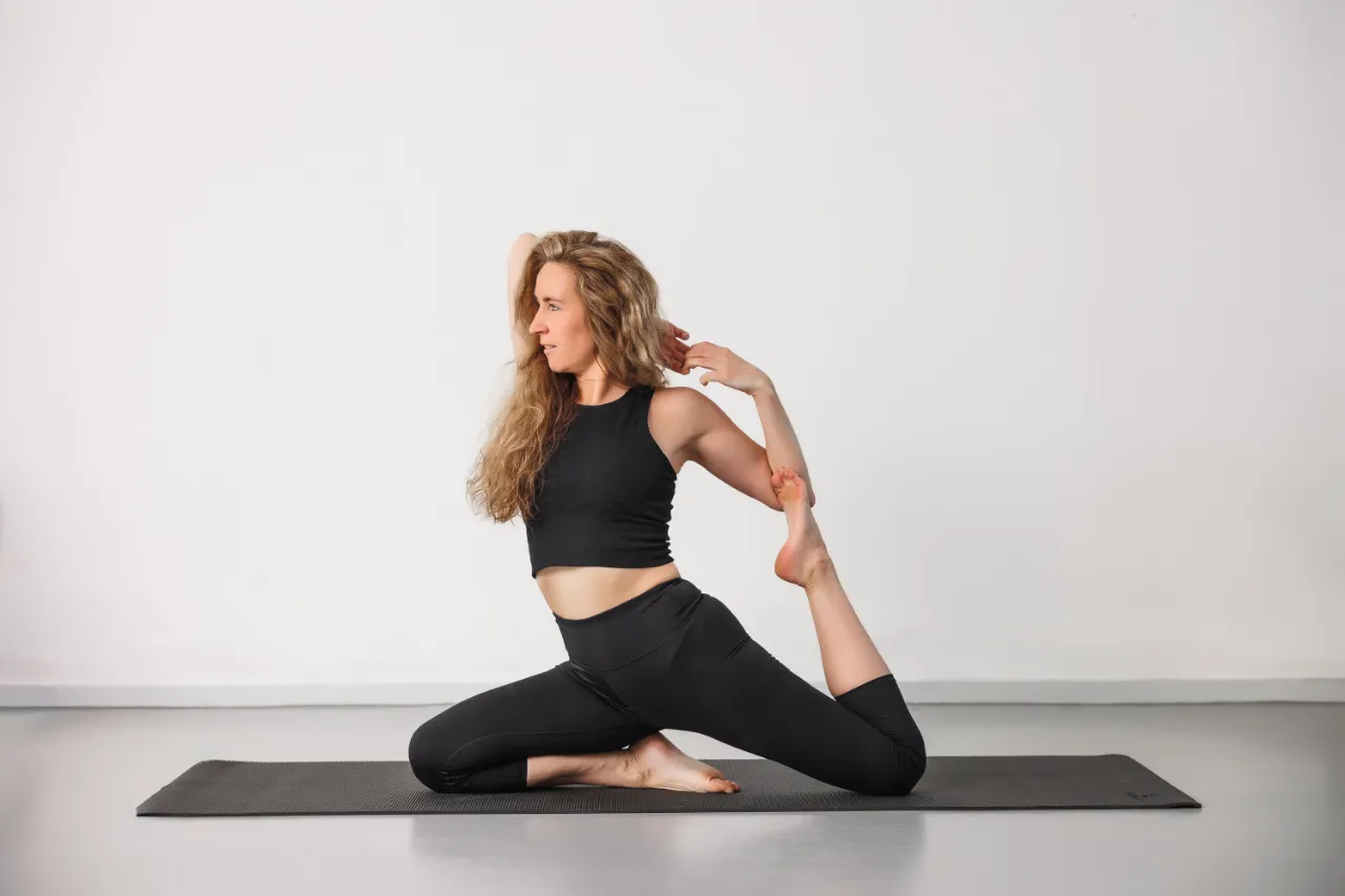 Vrouw in een yogahouding op de mat