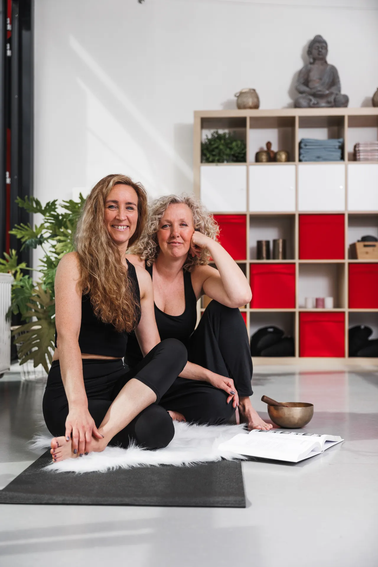 Twee lachende vrouwen in de yogastudio