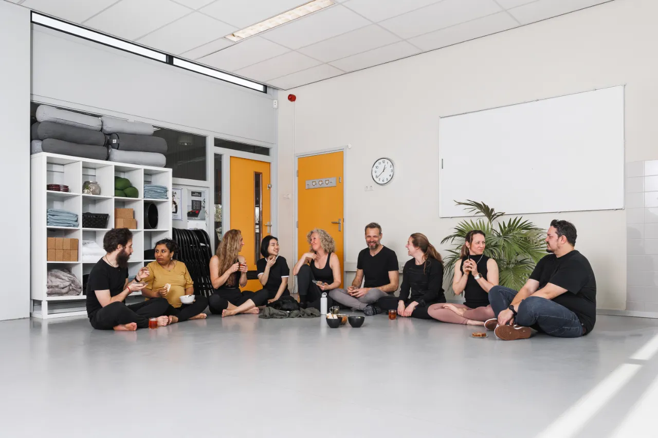 Groep ontspant samen op de vloer in de studio